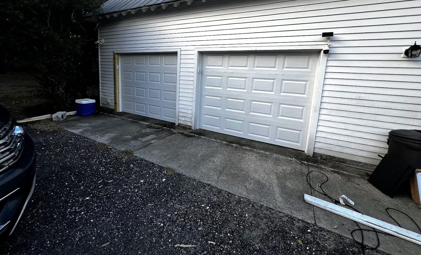 Two new white raised panel garage doors on a farmhouse style detached garage